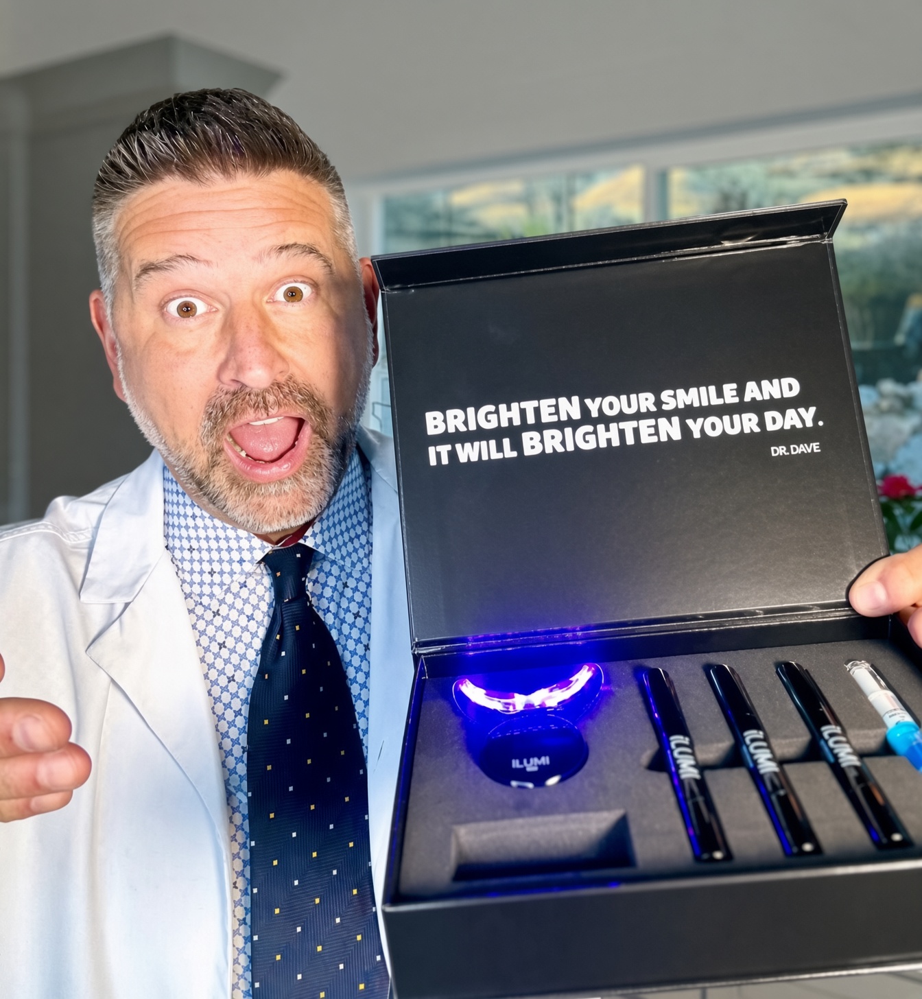 Dr. Dave Steuer presenting the open ILUMI LED Teeth Whitening Kit with the lit LED device beside the open box